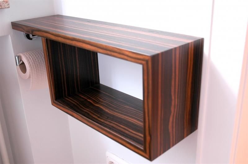 Ein Holzregal mit einem daran befestigten Toilettenpapierhalter