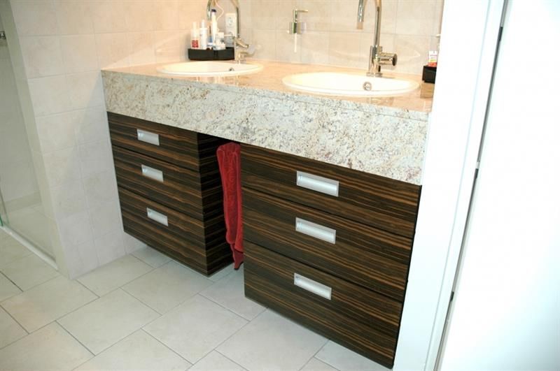 Ein Badezimmer mit zwei Waschbecken und Schubladen darunter