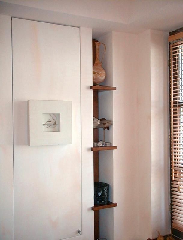 Ein Bild an einer Wand über einem Regal in einem Zimmer