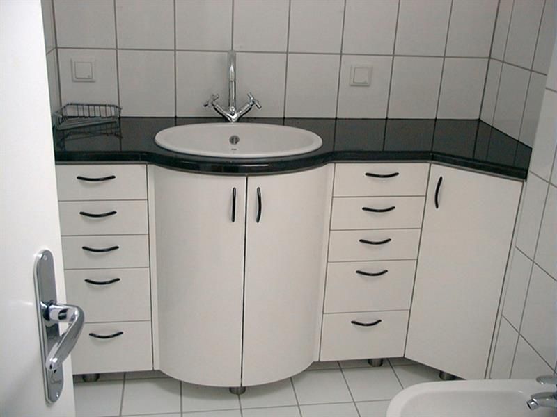 Ein Badezimmer mit weißen Schränken und Schubladen und einem Waschbecken