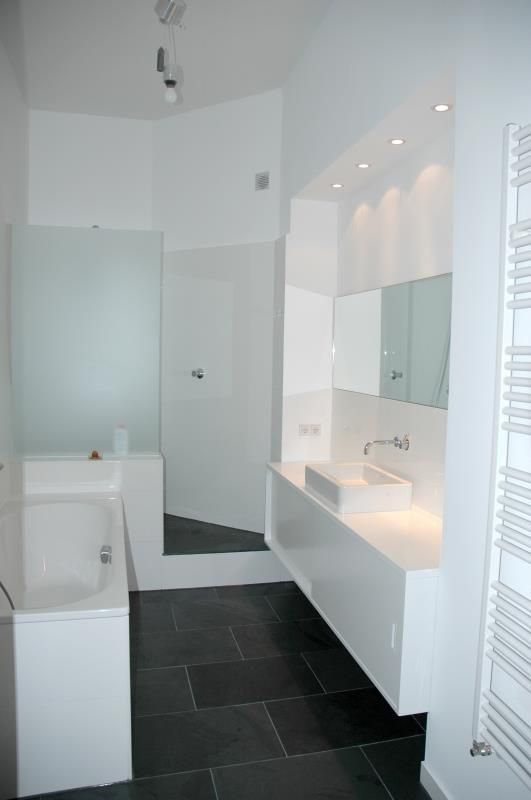 Ein Badezimmer mit Badewanne, Waschbecken und Spiegel