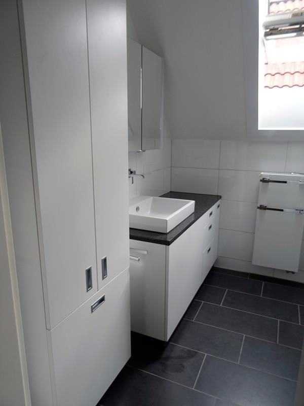 Ein Badezimmer mit Waschbecken, Schränken und Fenster