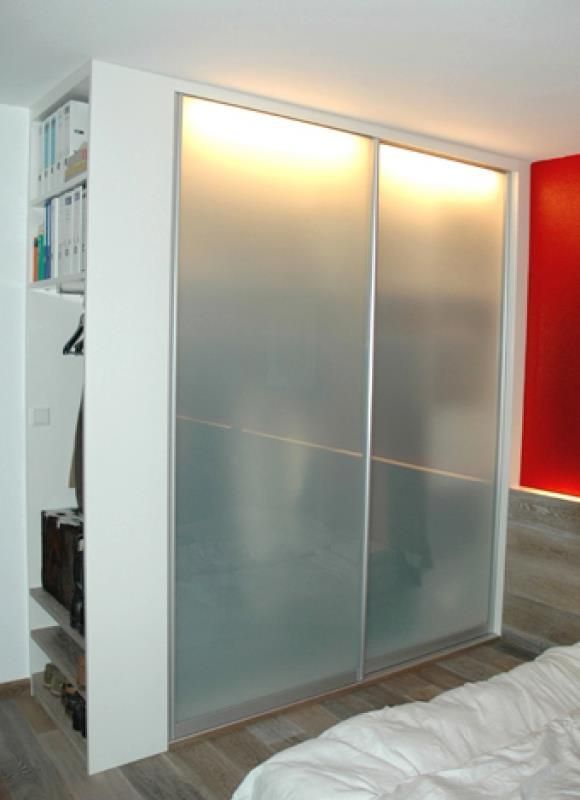 Ein Schlafzimmer mit Glasschiebetüren und einer roten Wand