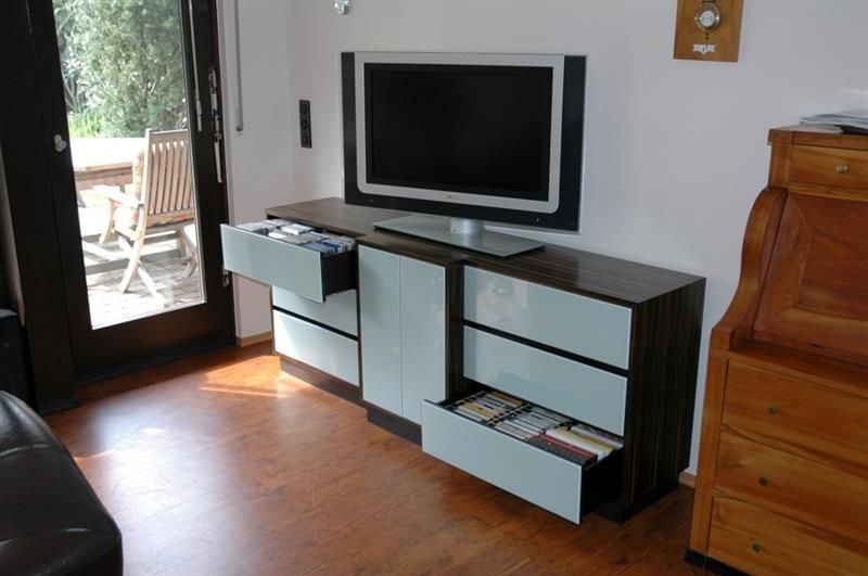 Ein Wohnzimmer mit Flachbildfernseher und Kommode