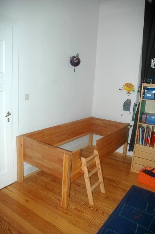 Ein Holzbett mit einer daran befestigten Leiter