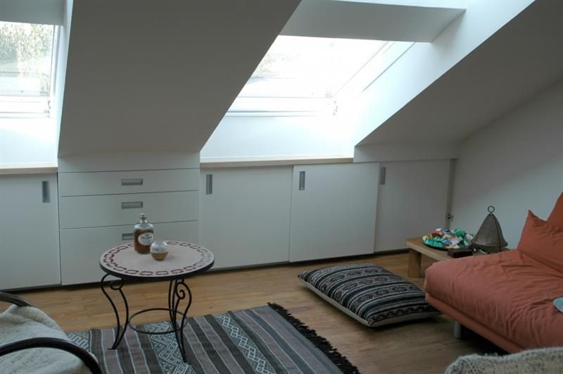 Ein Wohnzimmer mit einer Couch, einem Tisch und einem Fenster