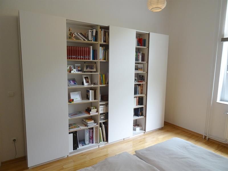 Ein Schlafzimmer mit einem Bücherregal voller Bücher und Bilder