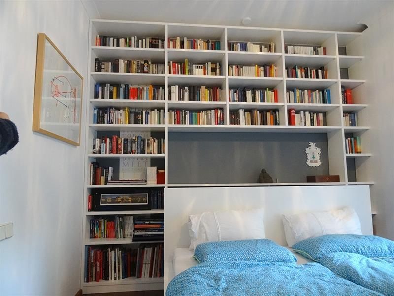 Ein Schlafzimmer mit zwei Betten und vielen Büchern in den Regalen