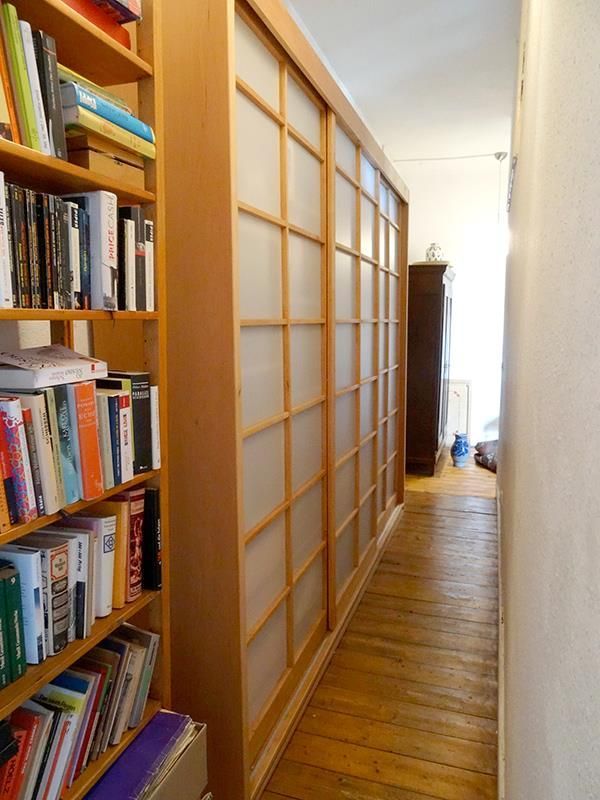 Ein Flur mit Bücherregalen und einer Glasschiebetür