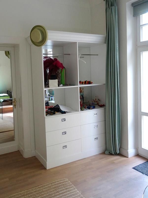 Eine weiße Kommode mit einem Hut darauf