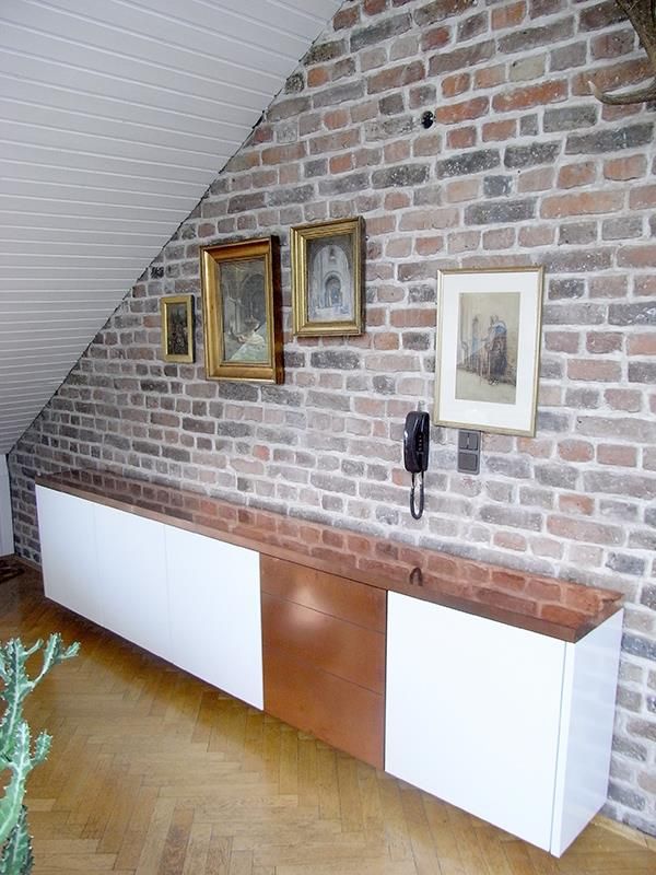 Eine Backsteinmauer mit Bildern darauf und einem Telefon darauf