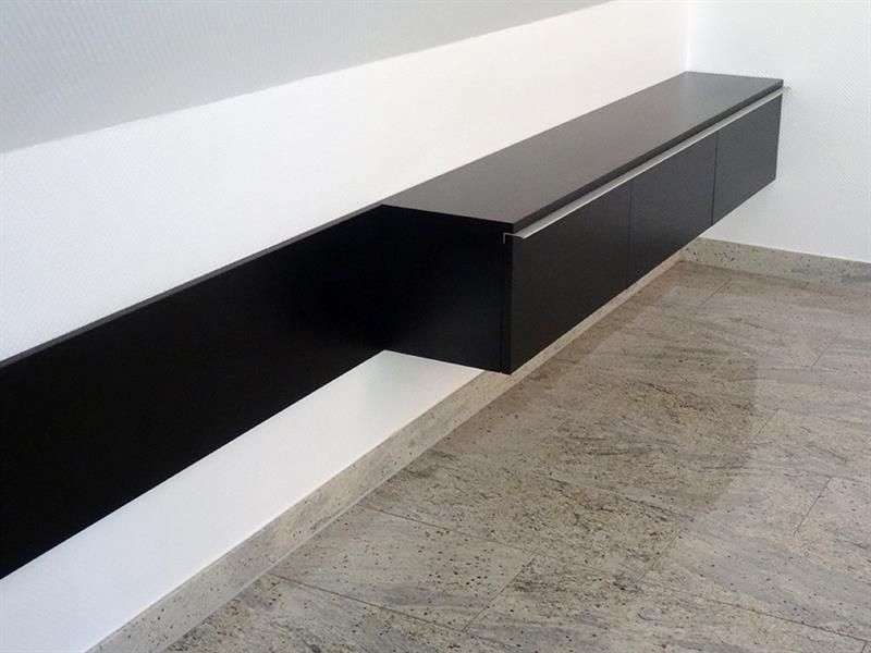 Eine weiße Wand mit einem schwarzen Regal darauf