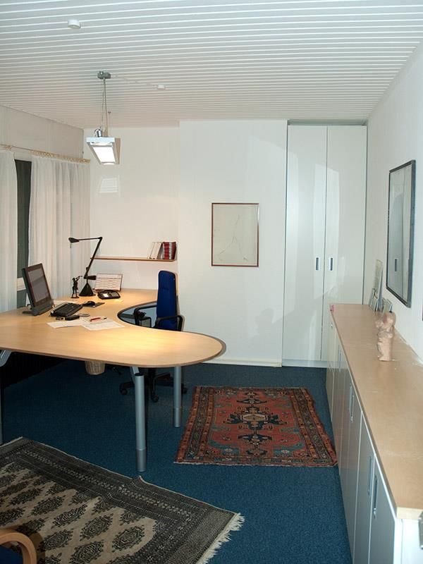 Ein Zimmer mit einem Teppich und einem Schreibtisch mit einem Computer darauf