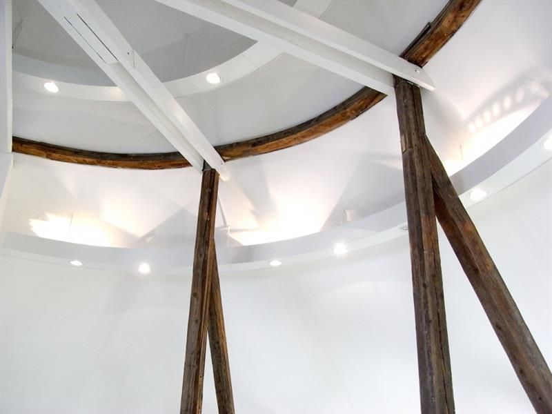 Ein Raum mit weißer Decke und Holzbalken