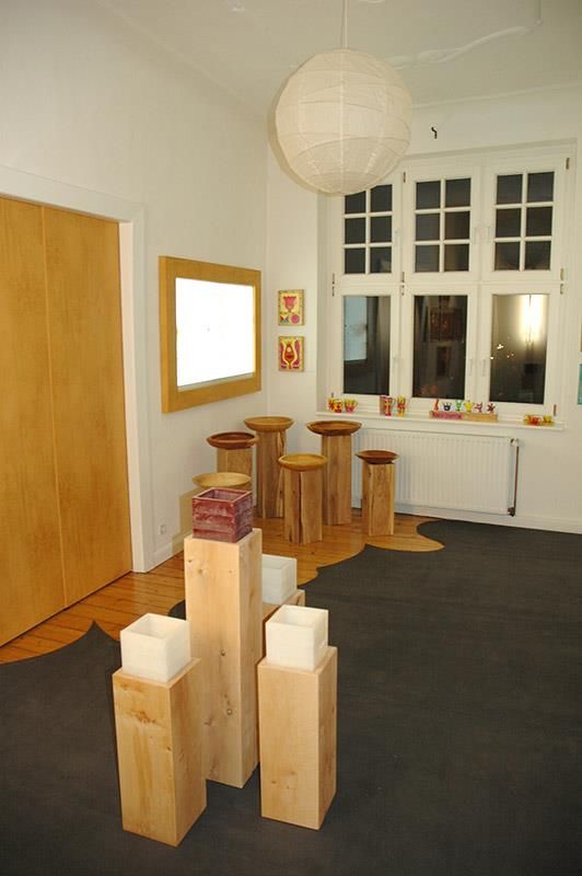 Ein Raum mit vielen Holzhockern und Kerzen