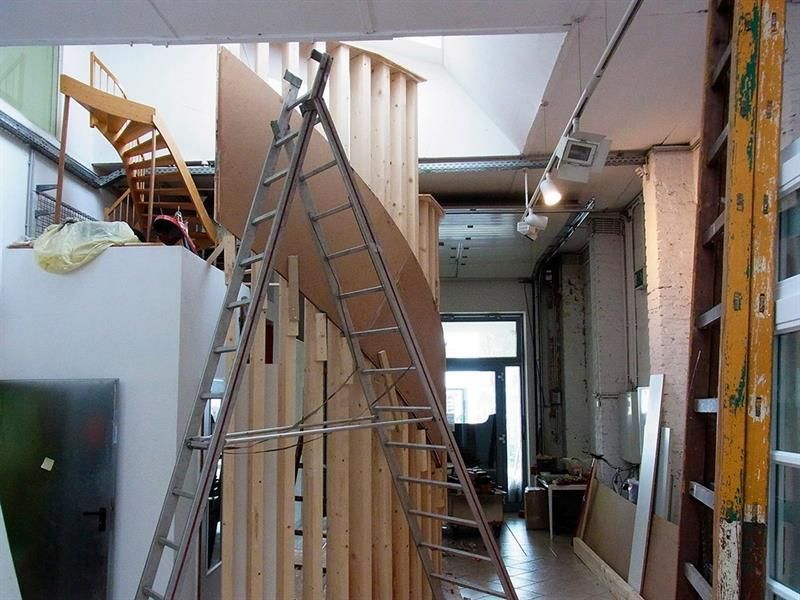 Eine Leiter in einem Raum mit einer Holztreppe