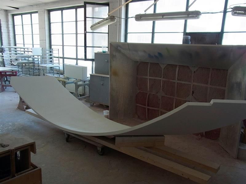 Ein großes Stück Holz liegt in einem Raum mit vielen Fenstern