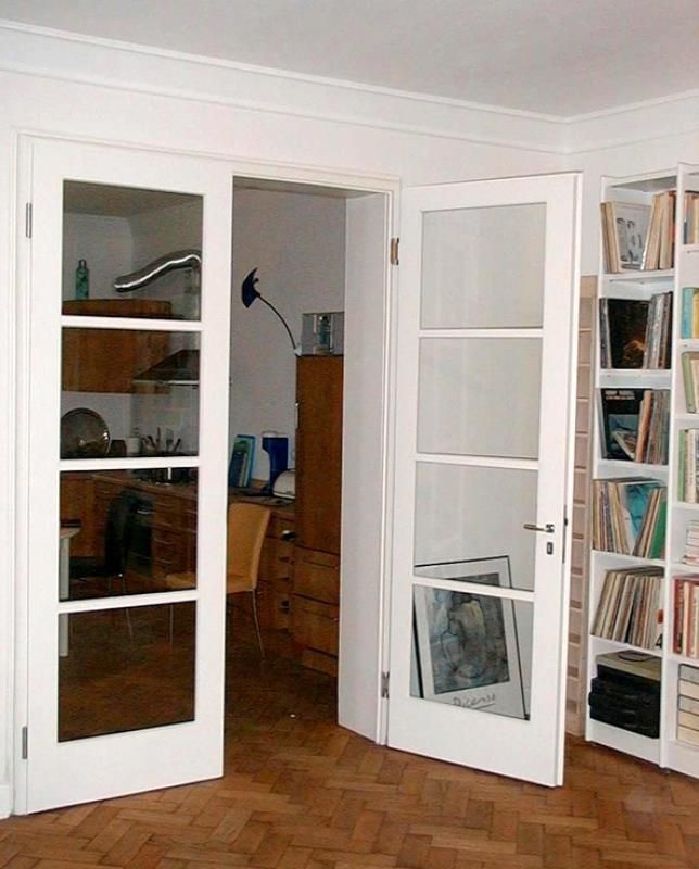 Ein Raum mit vielen Bücherregalen und weißen Türen