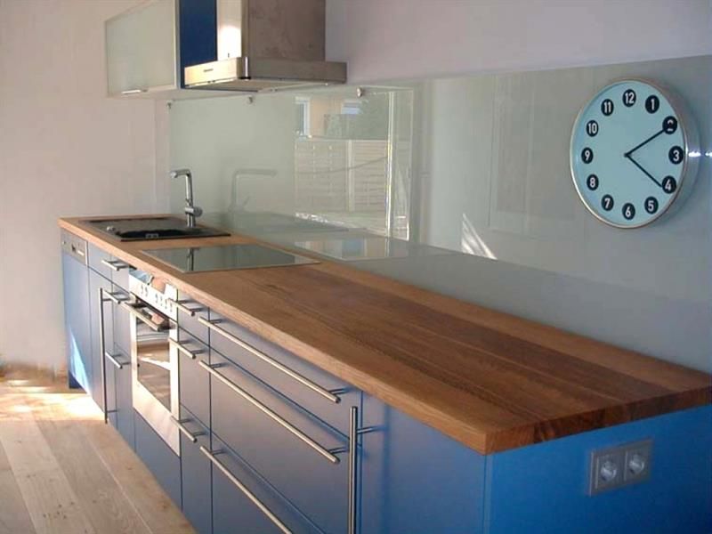 Eine Küche mit blauen Schränken und einer Uhr an der Wand