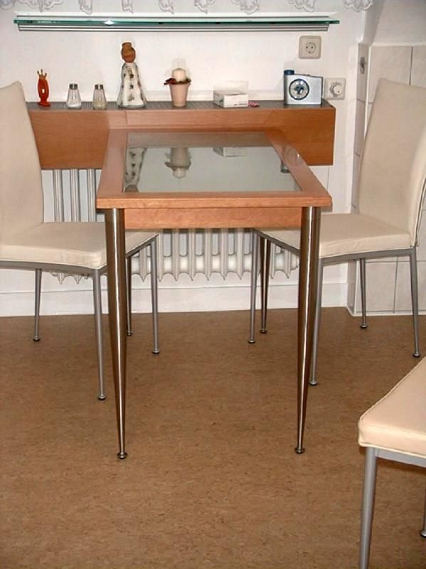 Ein Tisch und Stühle in einem Raum mit einer Uhr an der Wand