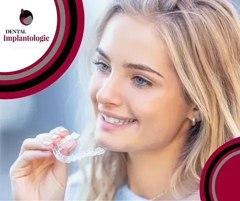 Una mujer sonríe mientras sostiene un aparato transparente en sus dientes.