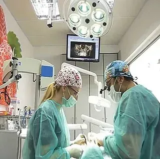 Un hombre y una mujer están operando a un paciente en un quirófano.