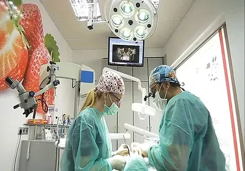 Un hombre y una mujer están operando a un paciente en un quirófano.