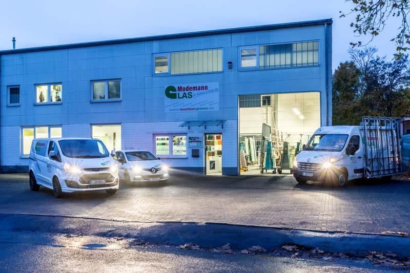 Drei weiße Lieferwagen parken vor einem Gebäude.