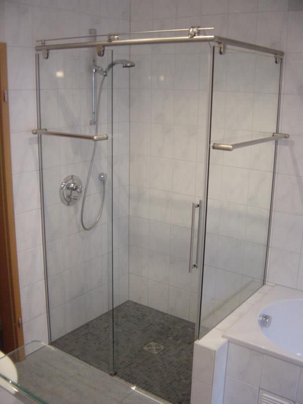 Ein Badezimmer mit einer Glasschiebeduschtür und einer Badewanne.