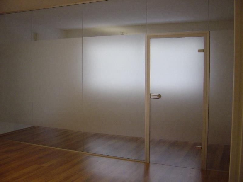 Ein Raum mit einer Glaswand und einer Glastür.