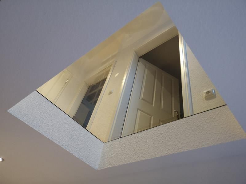 Eine Tür spiegelt sich in einem Spiegel an der Decke