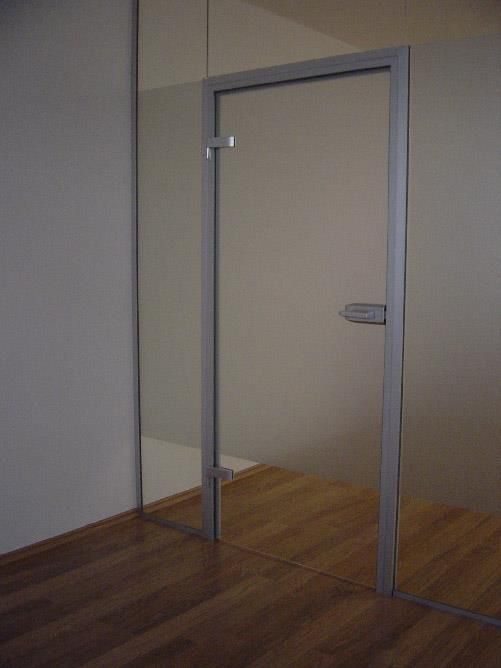 Ein leerer Raum mit einer Glastür und einem Holzboden.