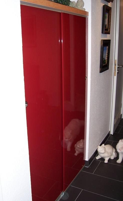 Ein Flur mit einer roten Tür und einer Schweinestatue auf dem Boden.