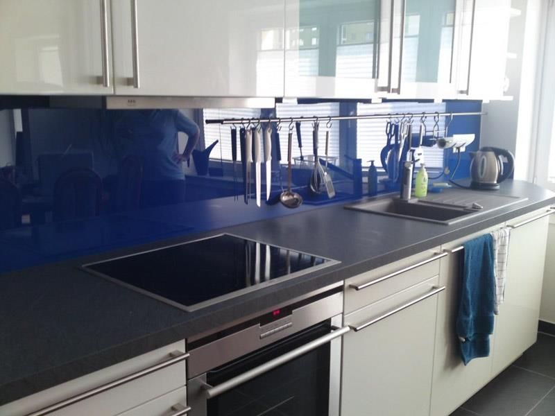 Eine Küche mit weißen Schränken und einer blauen Arbeitsplatte