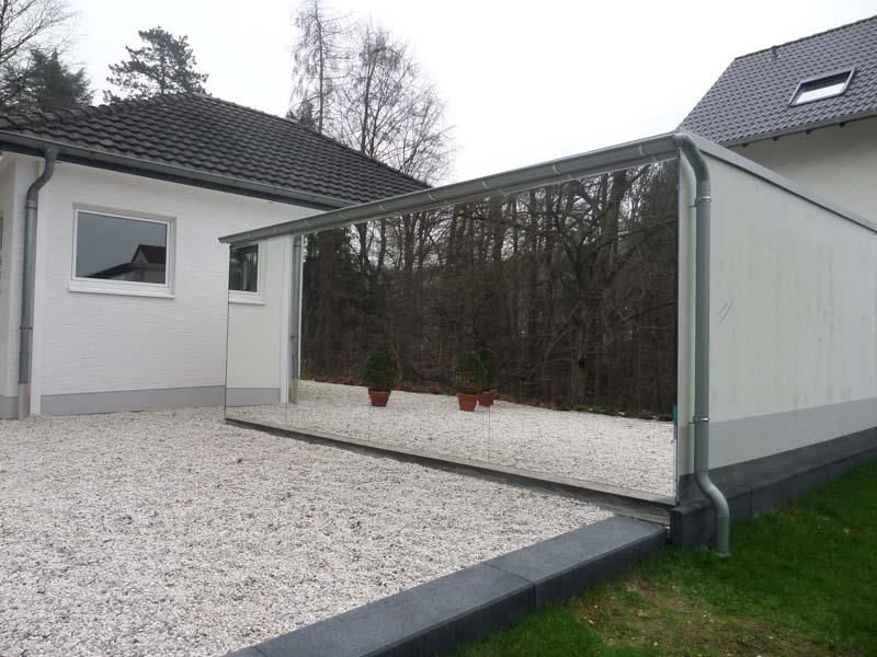 Ein weißes Haus mit einer Kiesauffahrt davor.