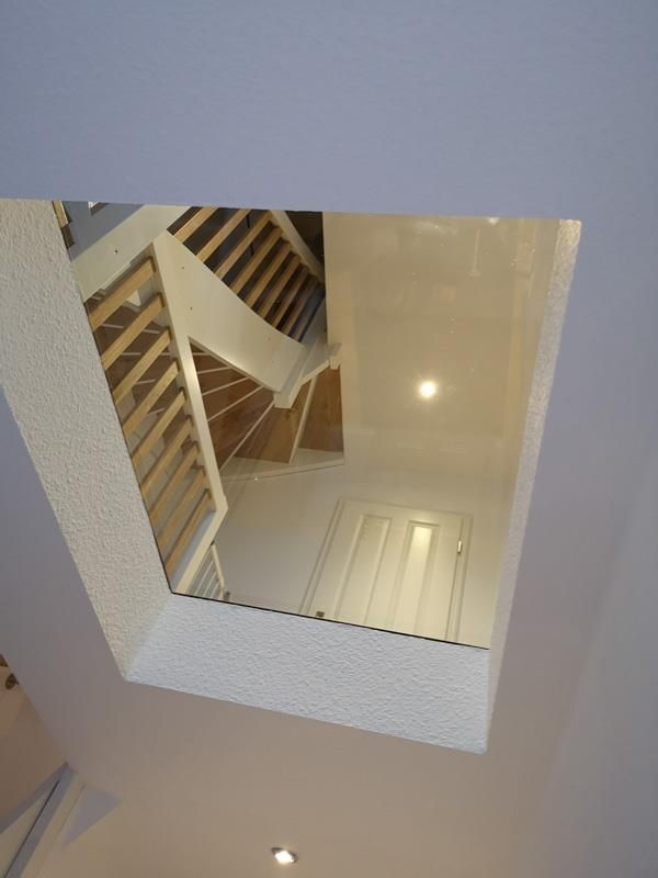 Blick nach oben auf eine Treppe mit einem Oberlicht in der Decke