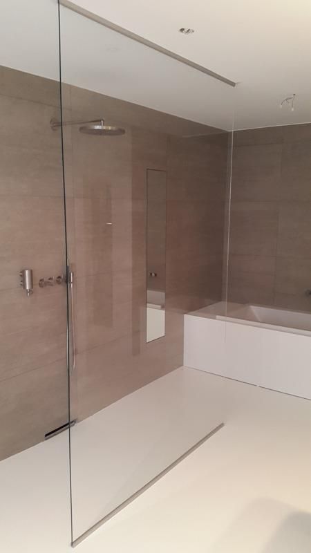 Ein Badezimmer mit ebenerdiger Dusche und Badewanne.