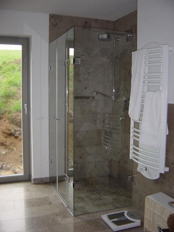 Ein Badezimmer mit ebenerdiger Dusche und einer Waage auf dem Boden.