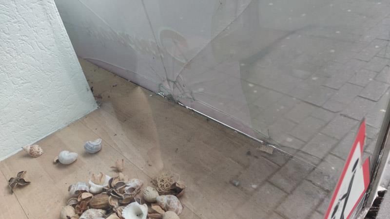 Ein Haufen Muscheln liegt auf dem Boden neben einer Glastür.