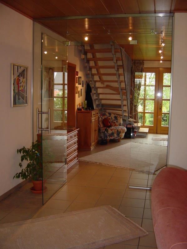 Ein Wohnzimmer mit einer Glastür, die zu einer Treppe führt