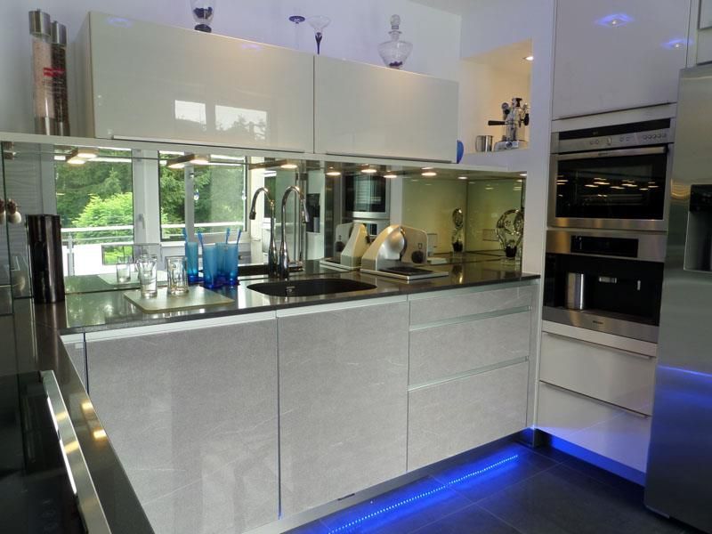 Eine Küche mit weißen Schränken und Geräten aus Edelstahl