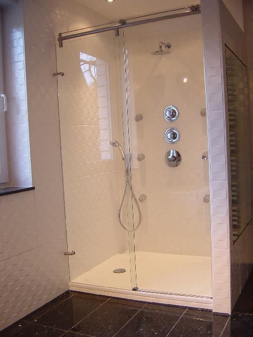 Ein Badezimmer mit ebenerdiger Dusche mit Glastür