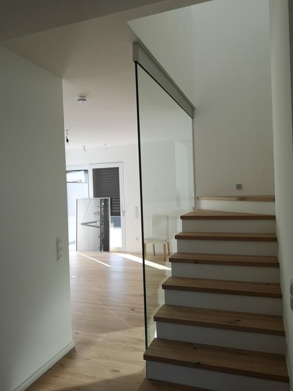 Eine Treppe mit Holzstufen und einem Glasgeländer