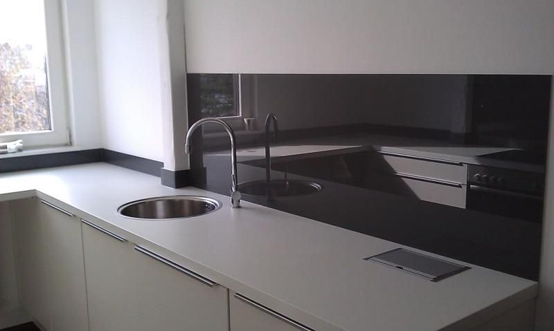 Eine Küche mit weißen Schränken und einer Edelstahlspüle