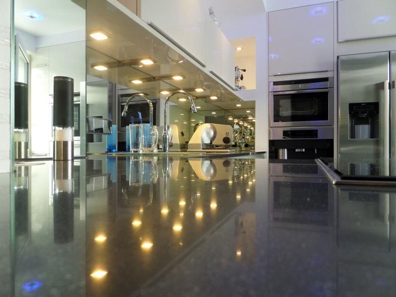 Eine Küche mit Geräten aus Edelstahl und einer schwarzen Arbeitsplatte