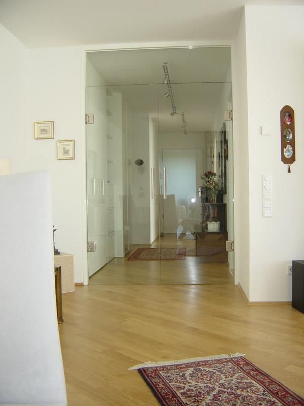 Ein Wohnzimmer mit einem Teppich und einer Uhr an der Wand