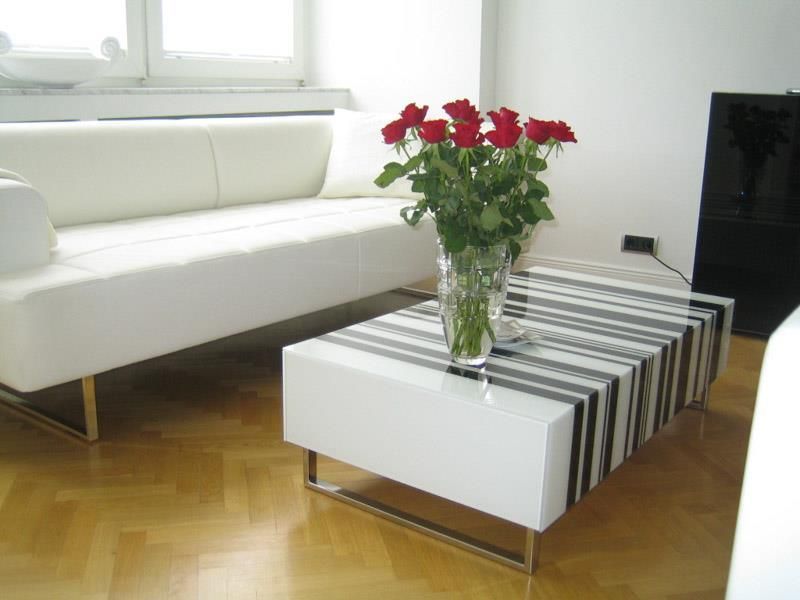 Eine Vase mit roten Rosen steht auf einem Couchtisch in einem Wohnzimmer