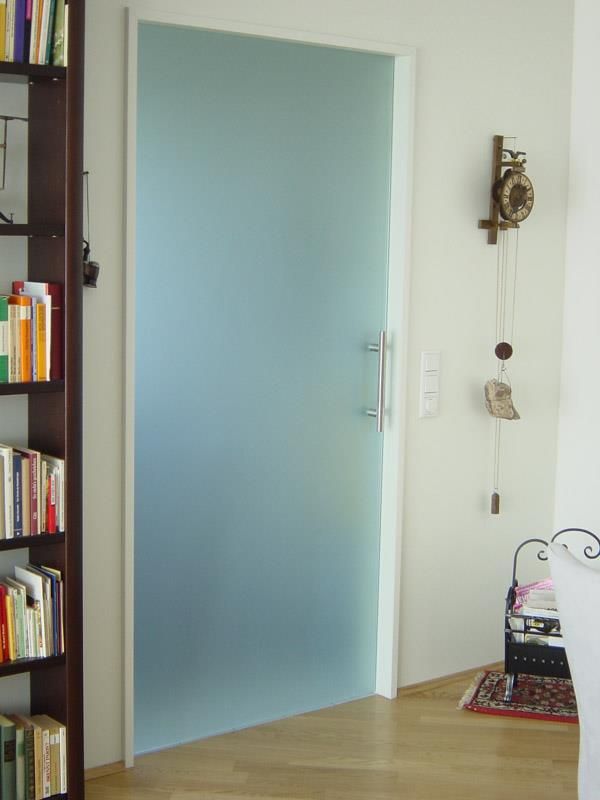 Ein Raum mit einer Glastür und einer Uhr an der Wand