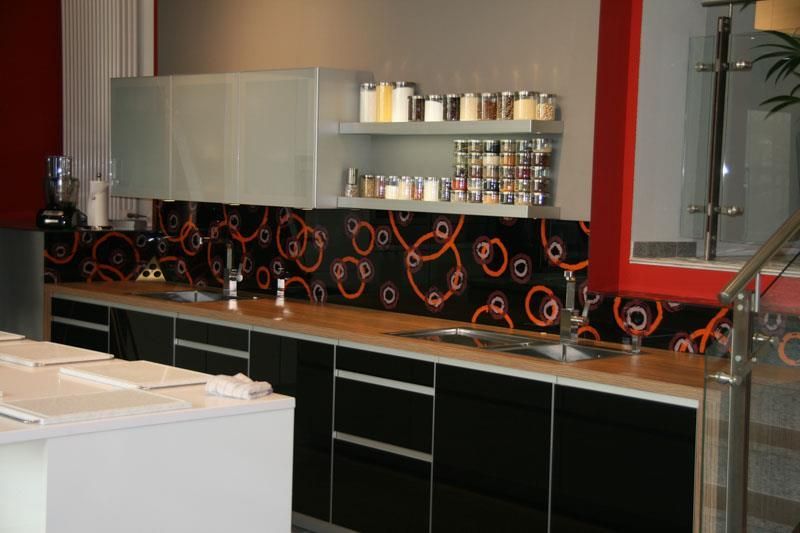 Eine Küche mit schwarzen Schränken und einer Spüle