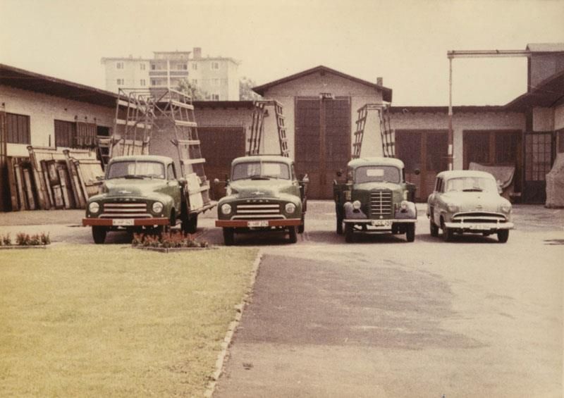 Eine Reihe alter Lastwagen parkt vor einem Gebäude